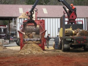 A large wood chipper processing tree debris into mulch at Renaud Tree Care in Dummerston, VT