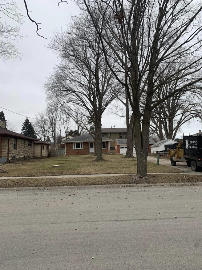 A wood chipper from Palasz Tree Service parked in a residential area in Milwaukee, WI, ready for tree work.