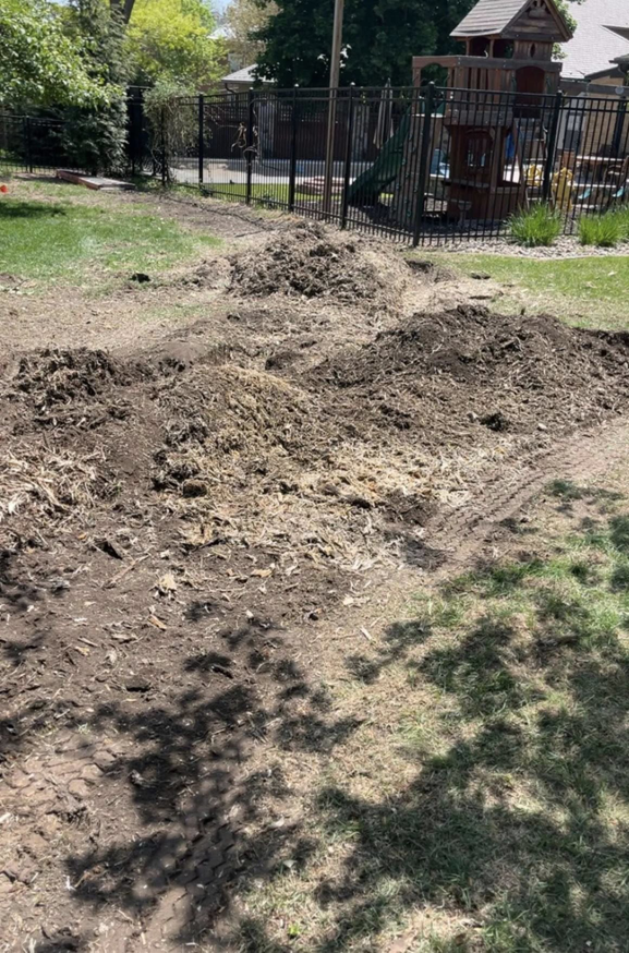 Piles of wood chips and debris on the ground after tree removal or stump grinding by Toben Tree Service in Yankton, SD.