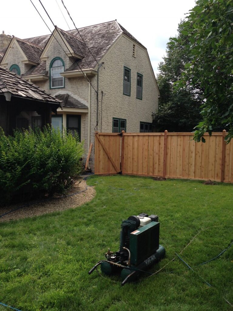 A new wooden fence with a small gate and steps leading to a residential property by Security Fence & Construction Inc in Minneapolis, MN.