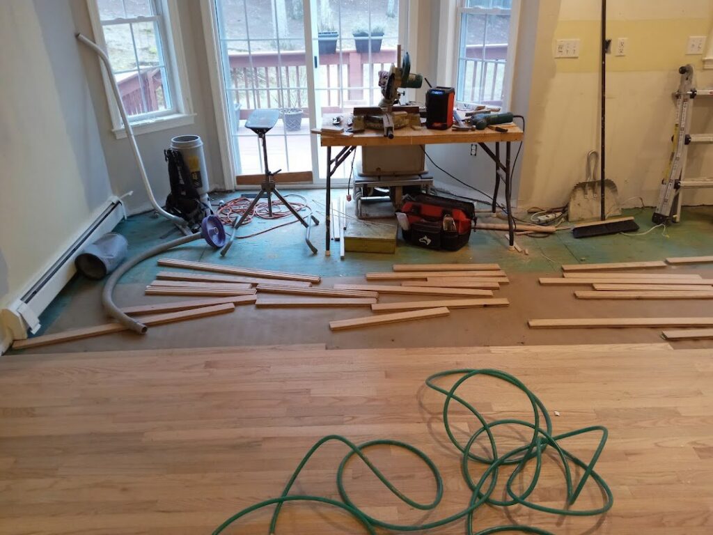 Wood floor installation in progress with tools and planks by Robert C. Mihaich Wood Flooring in Worcester, MA.