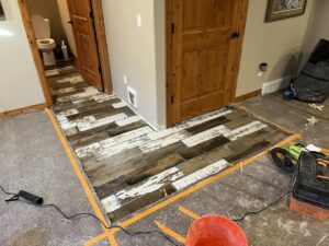 Wood-look floor tile installation in progress in a hallway by High Plains Craftsmen in Cheyenne, WY.