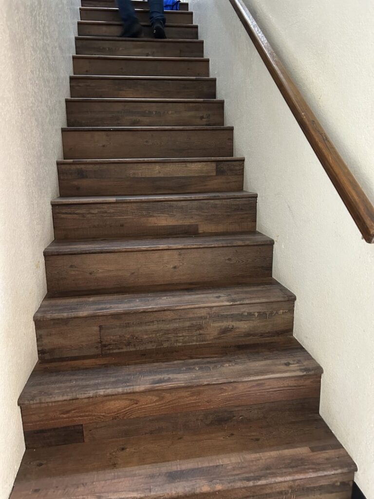 Completed installation of wood-look flooring on stairs by MDN Roofing 2 Flooring LLC in Fort Worth, TX.