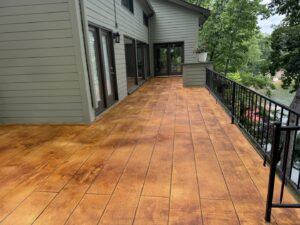 A spacious deck with a realistic wood-look stamped concrete surface, installed by Rodriguez Concrete Creations in Rock Hill, SC.