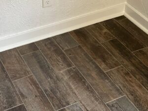 New wood-look tile flooring and white baseboards installed by Top Notch Contracting in Racine, WI.