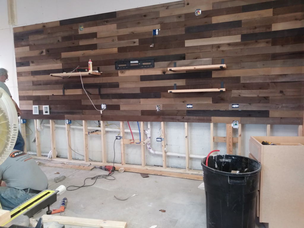 Wood paneling, electrical outlets, and shelving being installed on a wall by Doug's Handyman Service in Sioux Falls, SD.