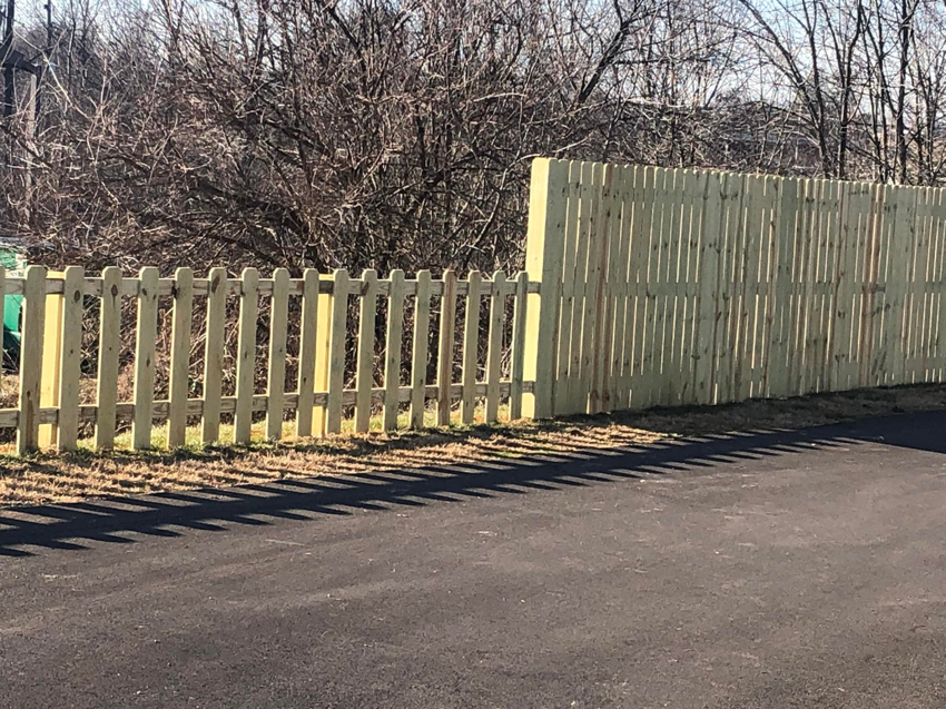 A long wooden fence featuring both picket and solid panel sections, installed by Fence & More in Elizabethtown, KY