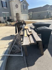 Wood planks and construction debris placed curbside for removal by SATX Junk-A-Haulics in San Antonio, TX.