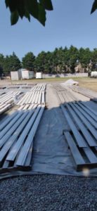 Outdoor view of wood planks laid out on tarps, prepped for painting by Bernardo Buildings Inc in Virginia Beach, VA.