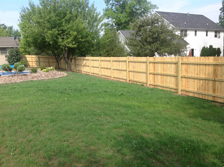 A wood privacy fence installation in a residential backyard by Woodsmith Fence Corp in Lockport, NY.