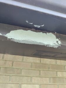 Close-up of wood filler or caulk applied to a wooden beam, indicating repair and preparation work by Homefix Lawrence in Lawrence, KS.