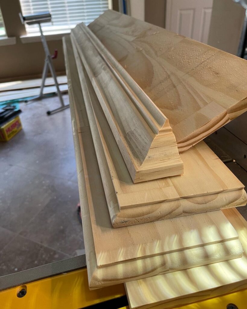 A stack of various wooden trim and molding pieces ready for installation, used by M7 Remodel & Restoration Inc. in Houston, TX