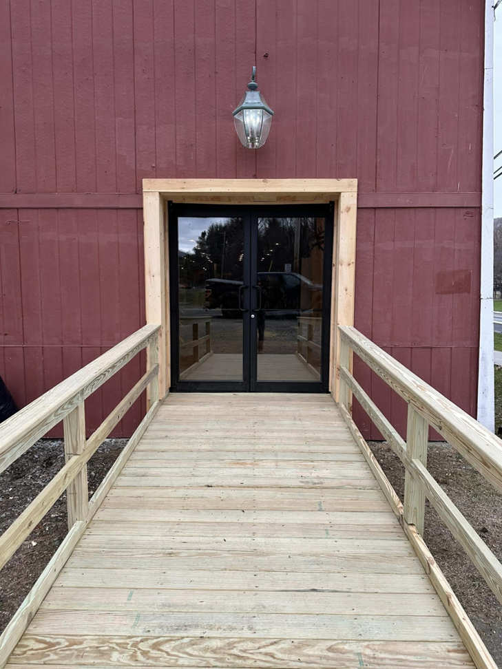 Newly constructed wooden access ramp and double door entrance by Next Generation Carpentry LLC in Bennington, VT.