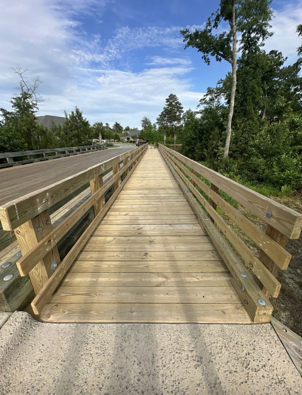 A newly constructed or repaired wooden boardwalk, showcasing quality handyman work by Unique Construction Concepts Inc in Wilmington, NC.