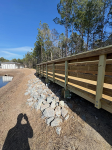 A newly built wooden boardwalk with riprap bank stabilization by Coastal Dock and Resurfacing in Beaufort, SC.