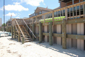 A sturdy wooden bulkhead with stairs leading to the beach, built by Spence Marine Construction Inc. in Virginia Beach, VA.
