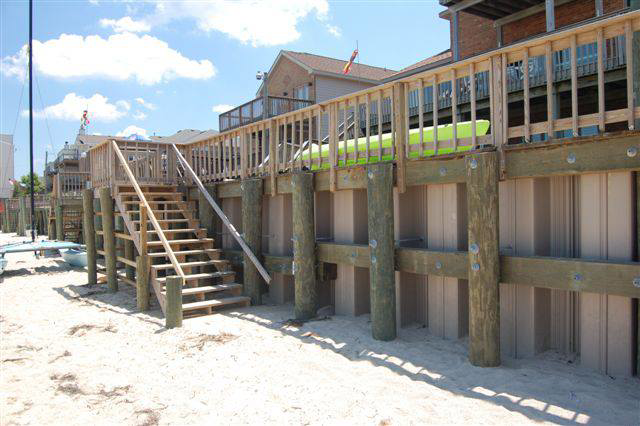 A sturdy wooden bulkhead with stairs leading to the beach, built by Spence Marine Construction Inc. in Virginia Beach, VA.