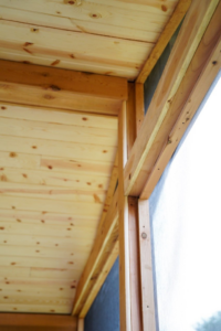 Close-up view of the wooden ceiling and framing of a newly built screened porch by Vision Construction in Framingham, MA.
