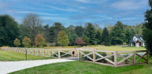Rustic wooden cross-buck style fence with a matching gate installed by National Fence Systems, Inc. in Avenel, NJ.