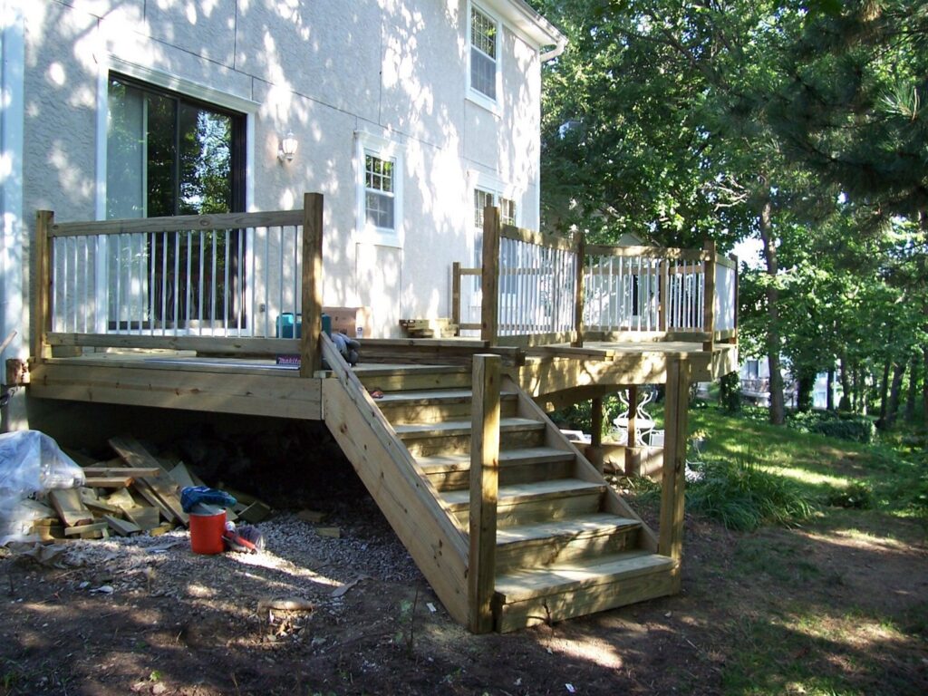 A wooden deck under construction with stairs and railings, built by Westlake Ace Handyman Services Kansas City Metro in Lenexa, KS.