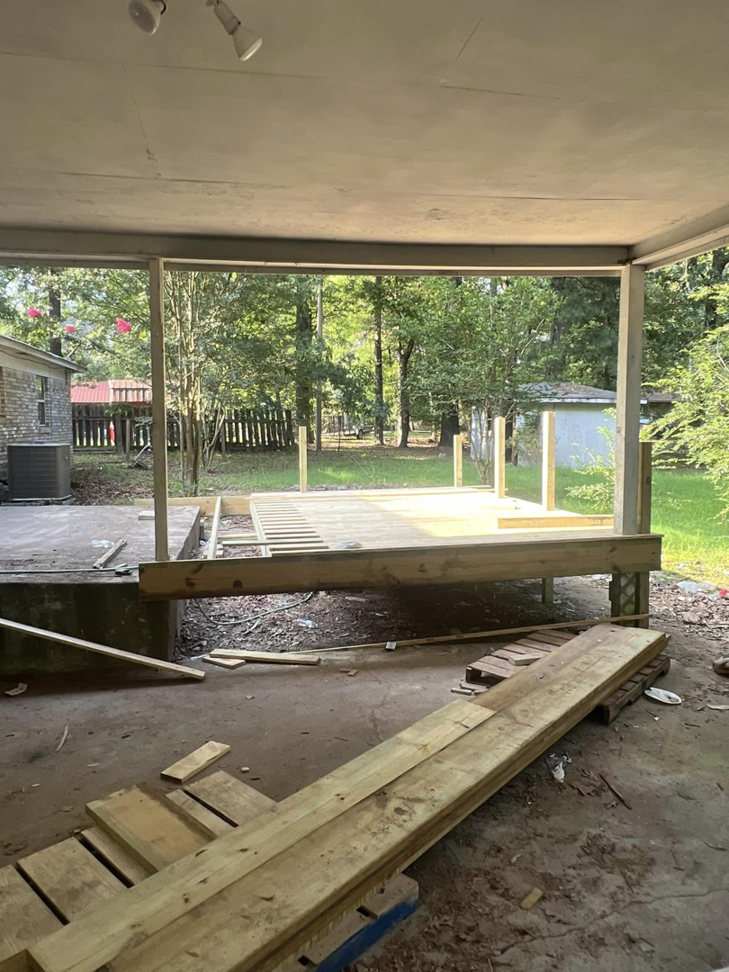 The wooden framework of a deck under construction, viewed from a covered patio by JD Handyman service LLC in Miami, FL.
