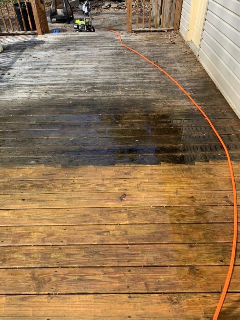 A wooden deck undergoing pressure washing, clearly showing the clean and dirty sections, by RepairTo Roofing, Renovations & Repairs in Wilmington, DE.
