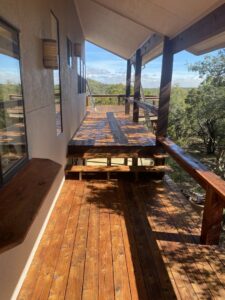 Newly stained or refinished wooden deck with a scenic view by Vargas Paint and Texture in San Antonio, TX.