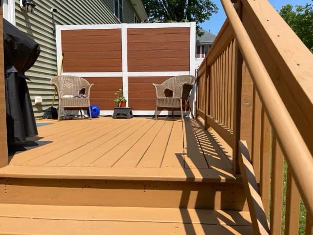 A renovated wooden deck featuring new steps and a privacy screen installed by Friendly Neighborhood Handyman in Uxbridge, MA.