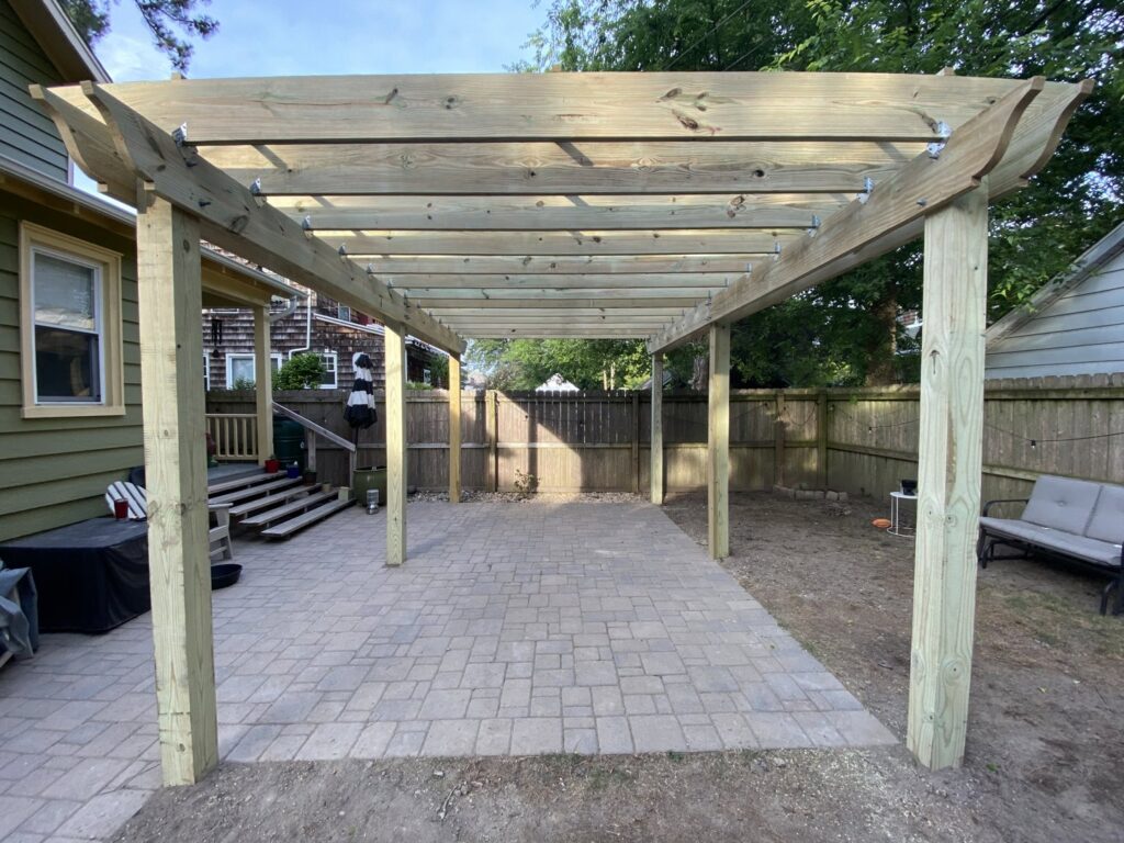 A custom wooden deck featuring a built-in bench and planters, constructed by Dutch Deck and Fence in Norfolk, VA.