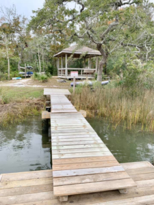 A newly constructed or repaired wooden dock leading to a gazebo by Southeast Custom Homes in Wilmington, NC.