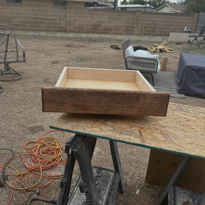 A wooden drawer on a workbench, indicating cabinet repair or installation by TS ELDER LLC in Phoenix, AZ