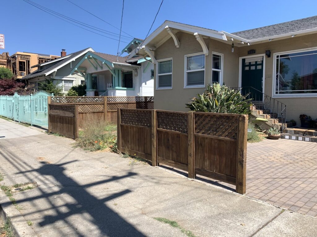 A custom wooden fence featuring decorative lattice panels, constructed by Dan's Home and Yard in Oakland, CA.