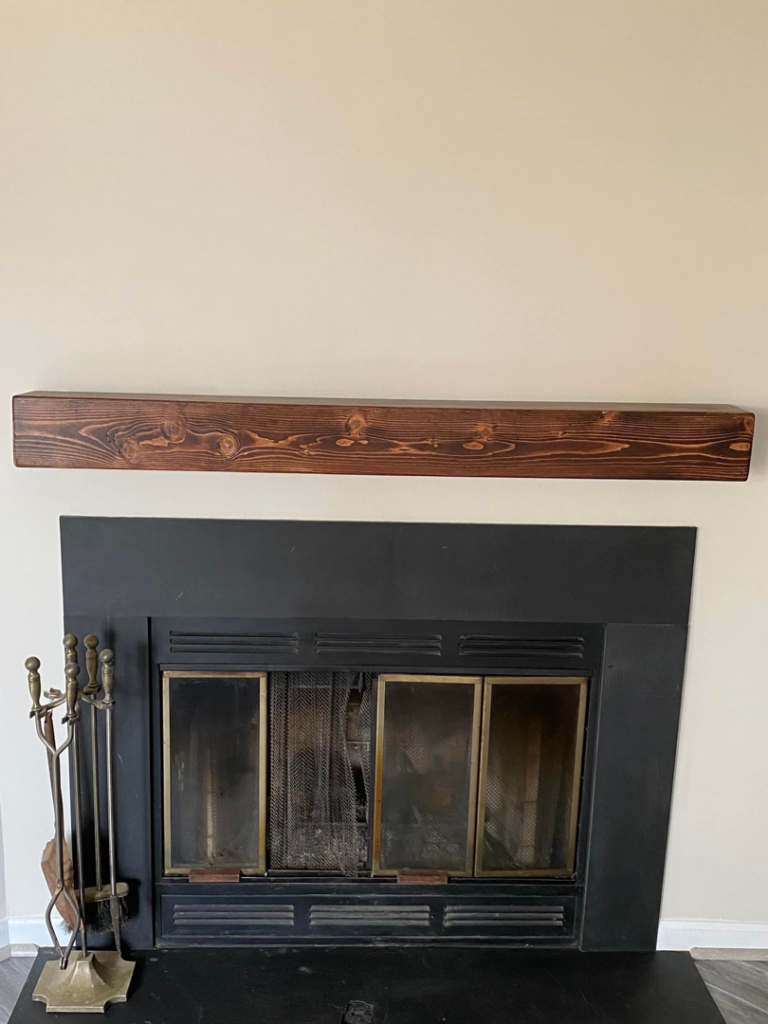 A newly installed wooden fireplace mantelpiece by Andyman,LLC in Fredrick, MD.