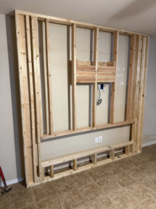 Wooden framing for a custom TV and electric fireplace wall unit by Camacho's Construction LLC in Laredo, TX.