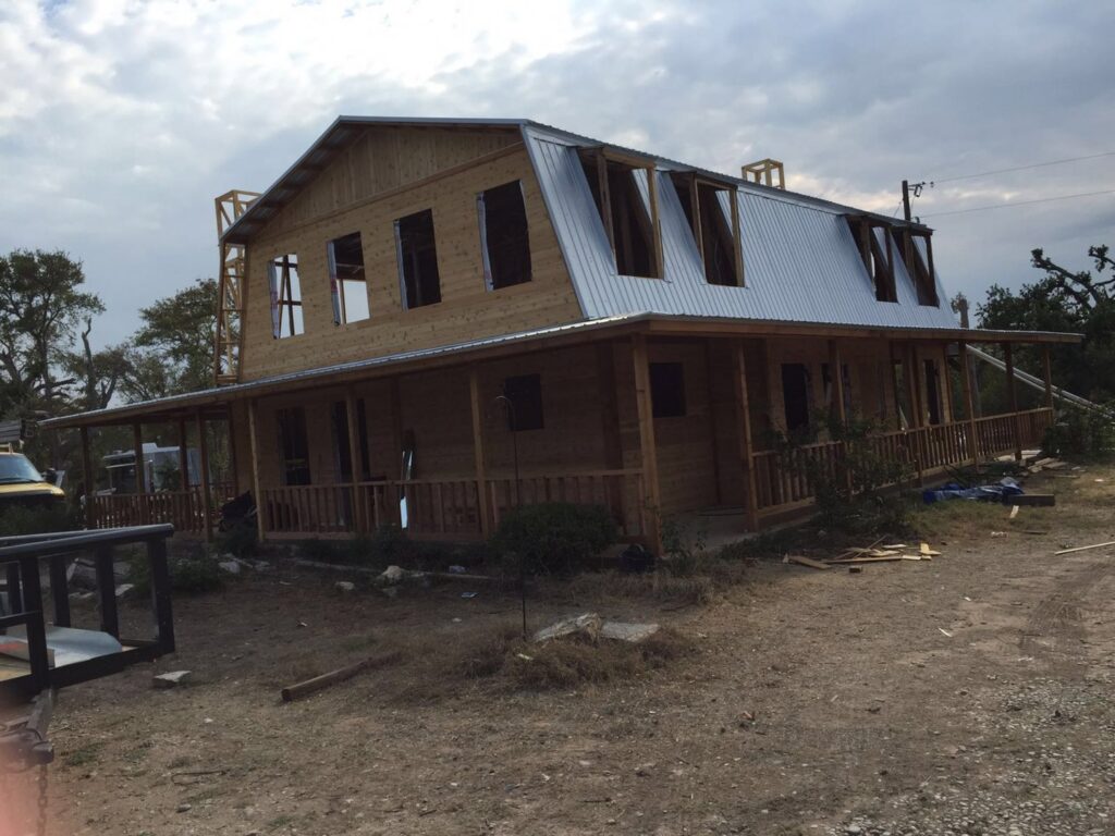 An angled exterior view of a wooden house under construction, highlighting roof and siding work by Savala's Remodeling Services in Austin, TX.