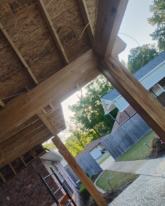 The wooden framework of a new patio cover under construction by Comeaux Home Services in Baton Rouge, LA.