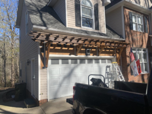 A newly installed wooden pergola above a garage door by Carolina Handyman Builder in Taylors, SC.