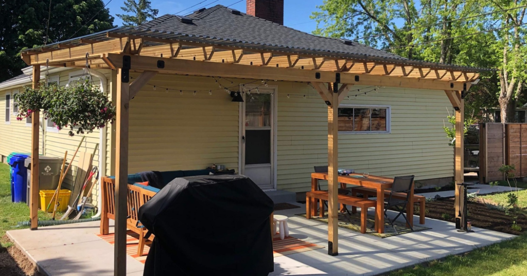A newly installed wooden pergola with a clear roof covering an outdoor patio by PNW Home Improvements, LLC in Portland, OR