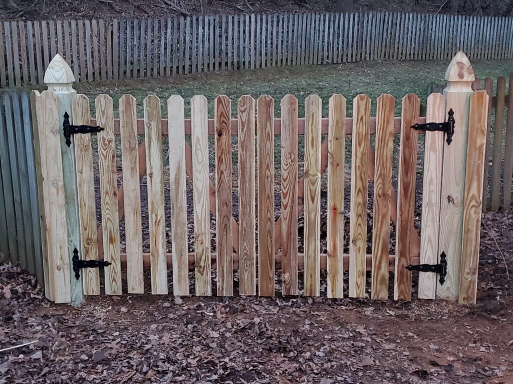 A newly installed wooden picket fence gate by Quality Fence & Deck Co. in Frederick, MD.