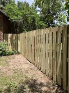 A newly installed wooden picket fence providing privacy and charm, built by Jack Of All Enterprises in Savannah, GA.