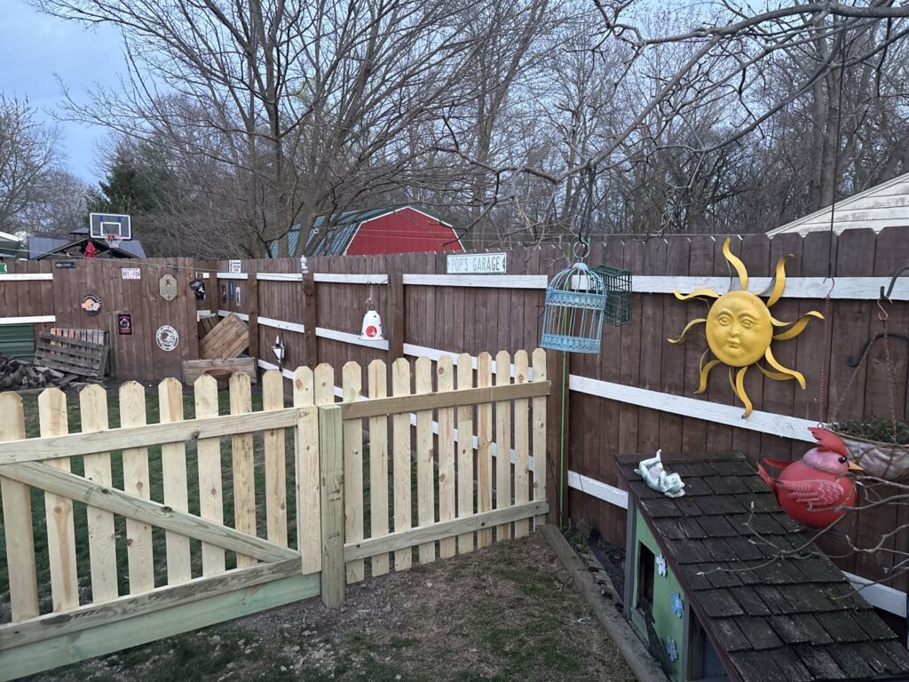 A section of new wooden picket fence installed in a backyard by Ofandiski Fence Co. Inc in Lorain, OH.