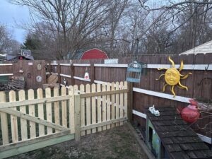 A section of new wooden picket fence installed in a backyard by Ofandiski Fence Co. Inc in Lorain, OH.