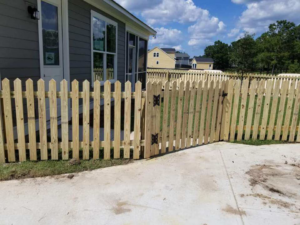 A newly installed wooden picket fence with a functional gate, completed by Frontline Fencing LLC in Summerville, SC.