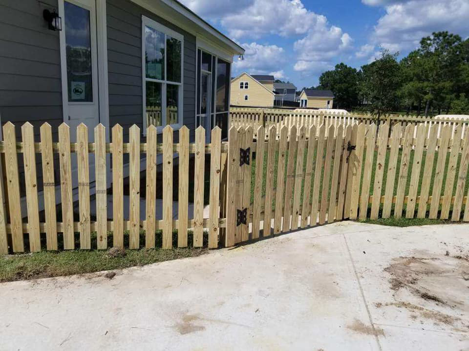 A newly installed wooden picket fence with a functional gate, completed by Frontline Fencing LLC in Summerville, SC.