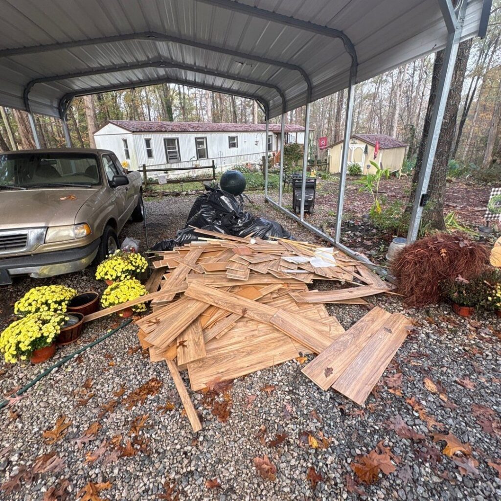 Wooden planks and black trash bags piled under a carport for junk removal by Veterans Easy Trash: Atlanta in Atlanta, GA.