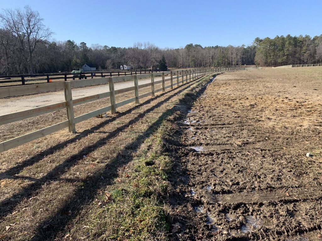 A long wooden post-and-rail fence installed in a rural setting by Premier Fence Company in Glen Allen, VA.