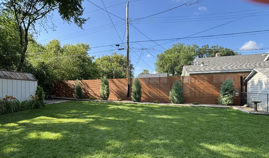 A newly installed wooden privacy fence in a backyard by The Cowboy Carpenter Handyman Service LLC in Bismarck, ND.