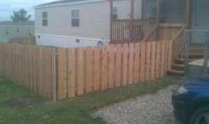 A newly installed wooden privacy fence surrounding a home, built by The Creative Carpenter in Minot, ND.