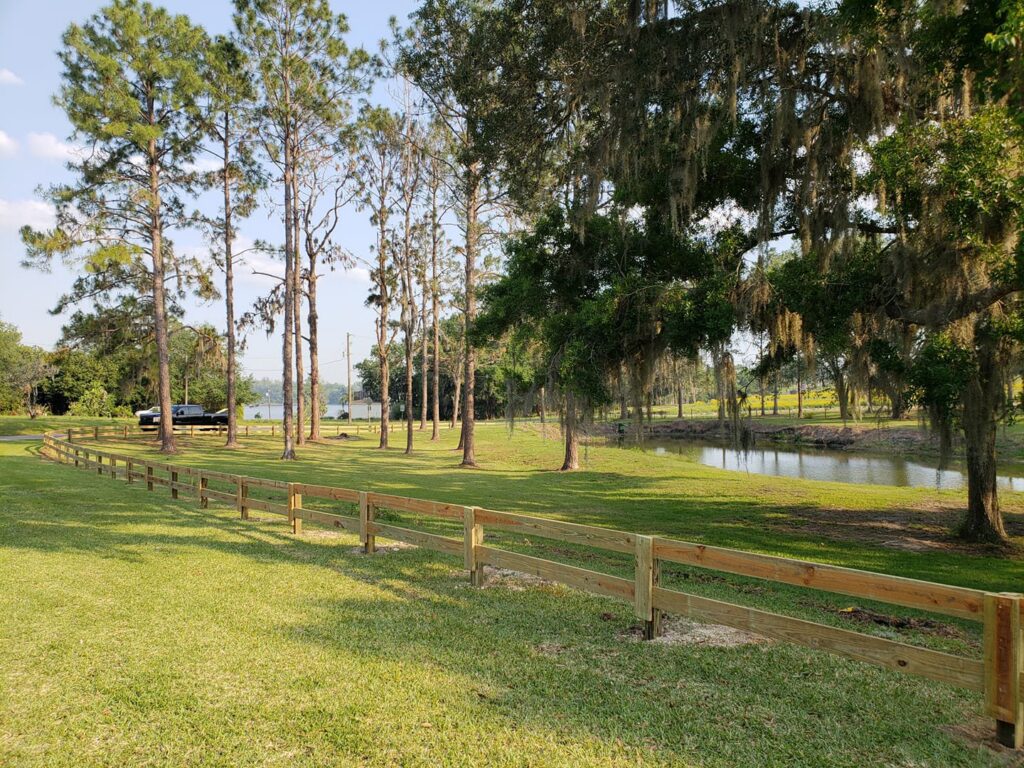 A rustic wooden split-rail fence installed in a rural setting by Keeler Fence in New Port Richey, FL.