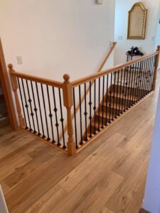 A newly installed wooden staircase with black metal balusters by Myers & Myers Construction in Spokane, WA.
